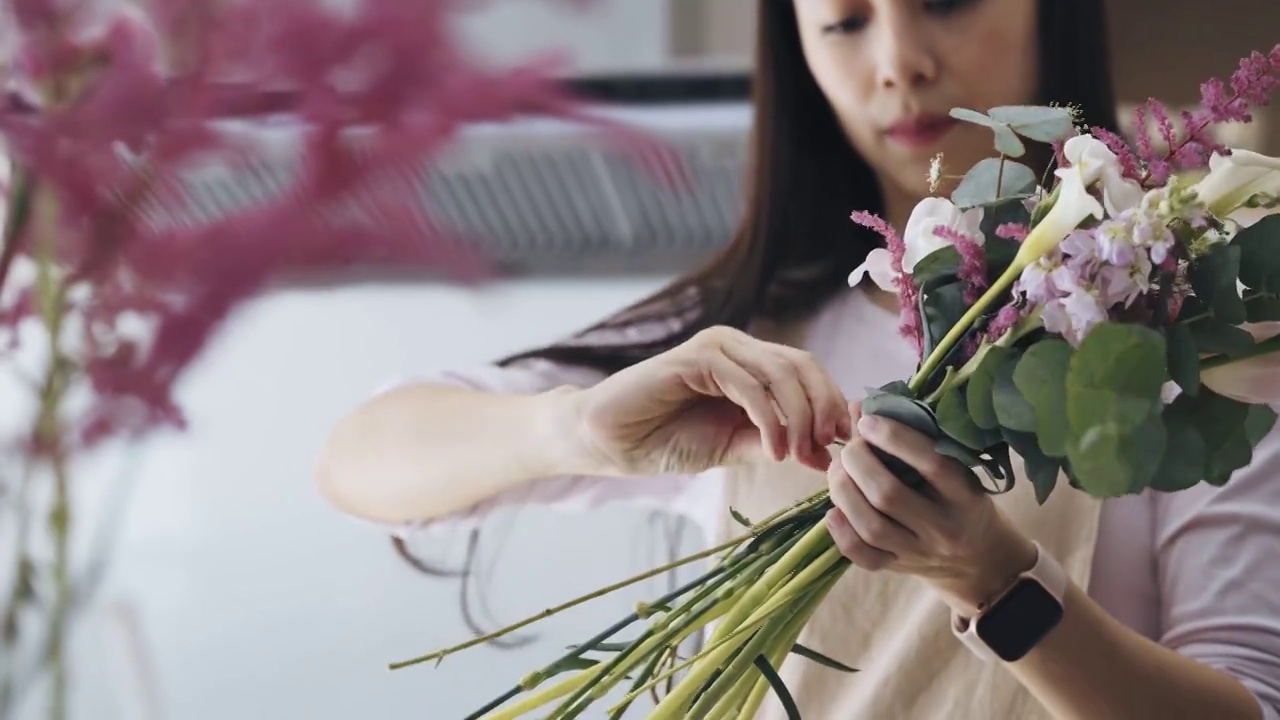 关闭亚洲女性花店，店主小生意花店，绑花花束。日常事务经营小企业的日常事务视频素材画面2