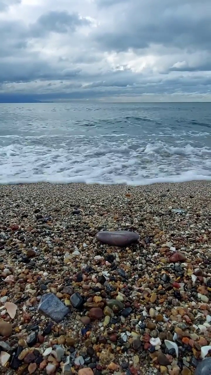 卵石滩上柔和的蓝色波浪视频素材