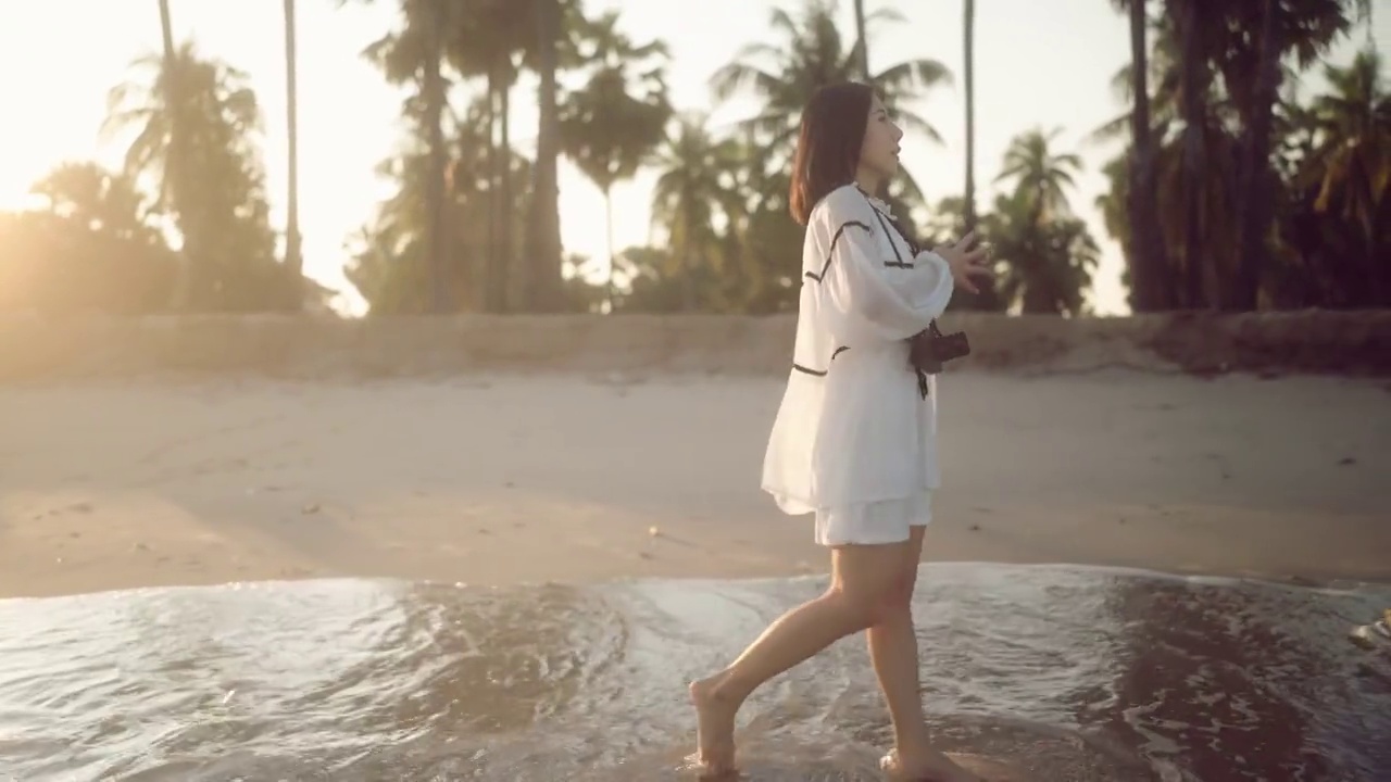 日落时分，幸福的女人走在海边视频素材