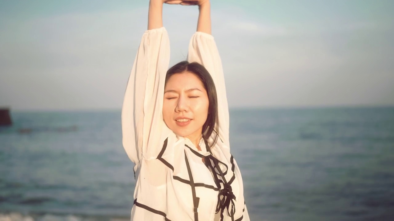 日落时分，幸福的女人走在海边视频素材