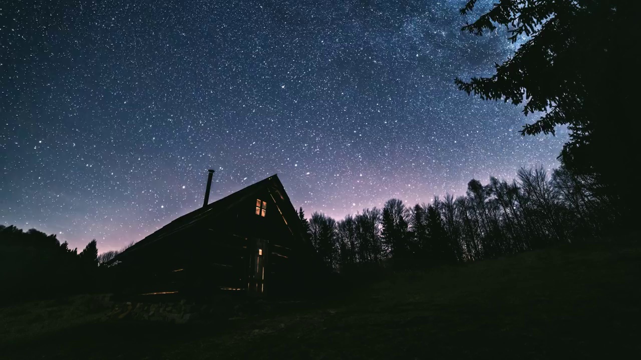 童话般的夜空，在原始森林的小木屋上，银河星系的数百万颗星星。天文学视频素材