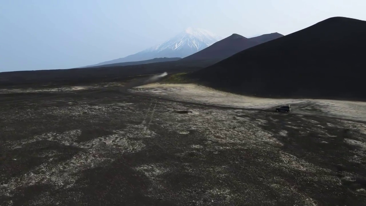 汽车在黑色的地球上行驶，俯瞰着火山视频素材