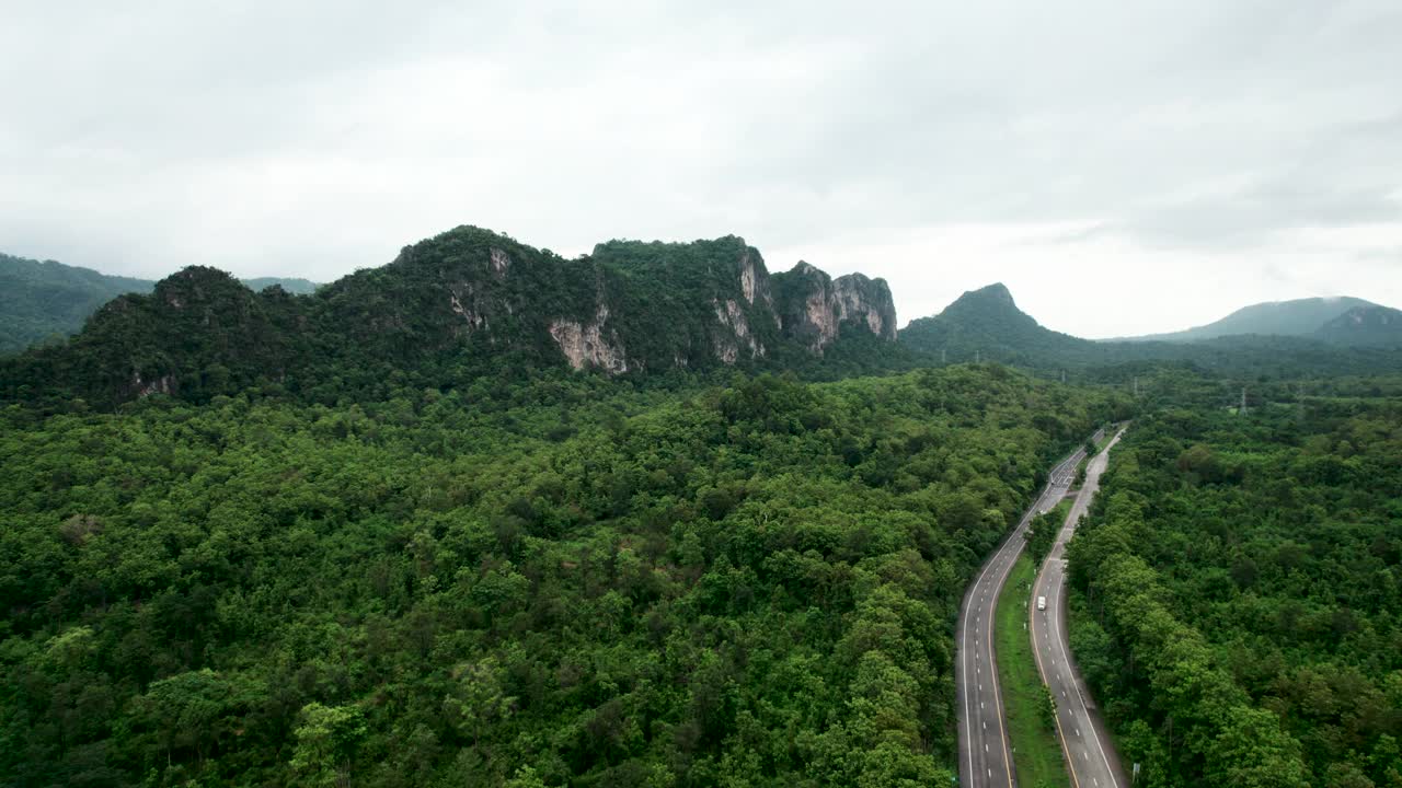 俯瞰通过绿色森林和山的乡村道路视频素材