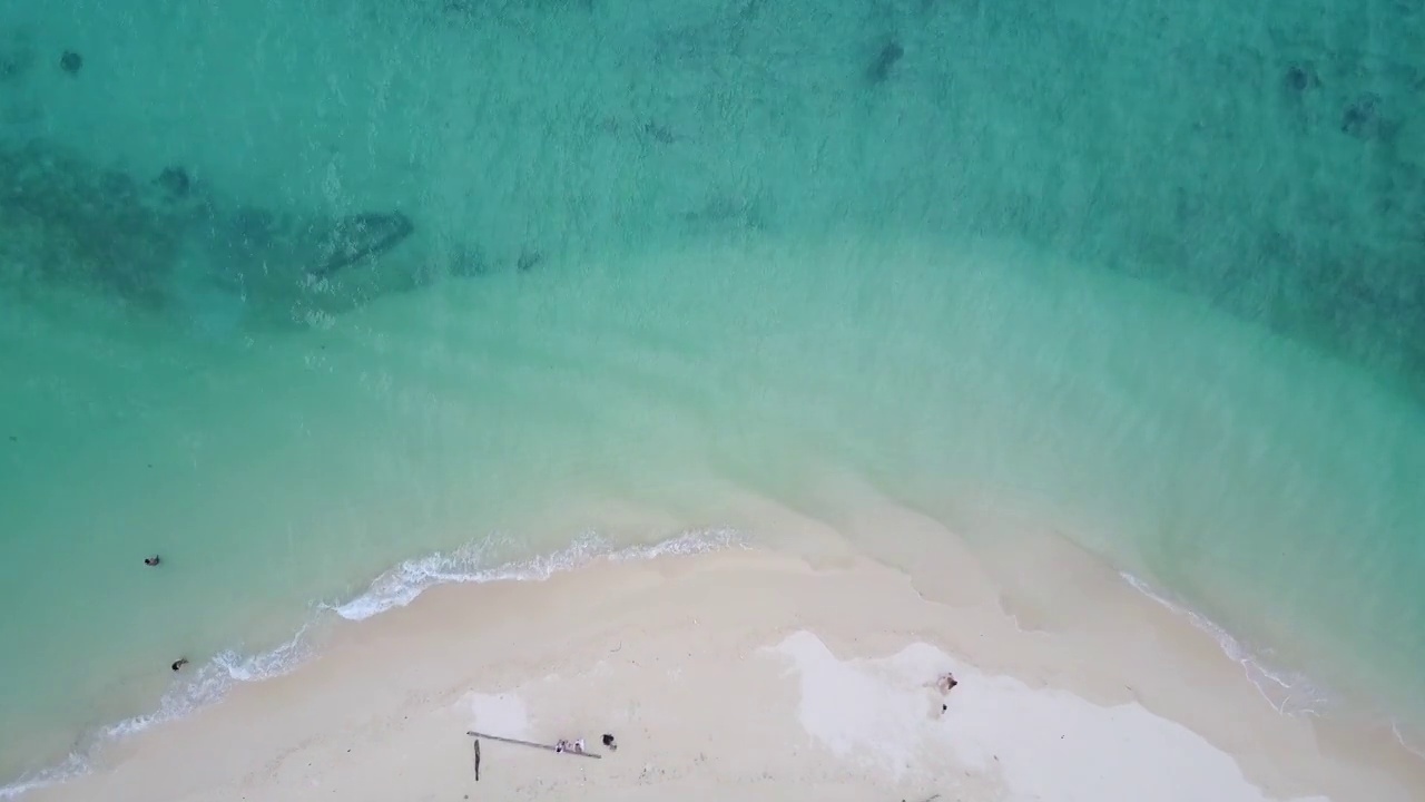 蓝绿色的海浪到达海岸线的鸟瞰图视频素材