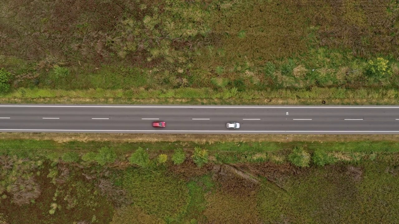 俯视图空中镜头的汽车在道路上通过乡村景观视频素材