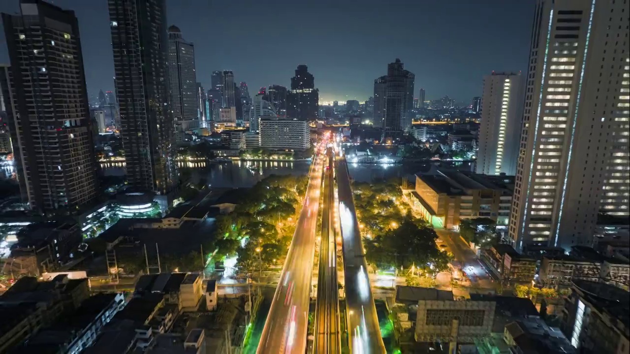 无人机超时间延时拍摄的日出场景，交通车灯在高速公路和地铁空中列车跨越湄南河在曼谷视频素材