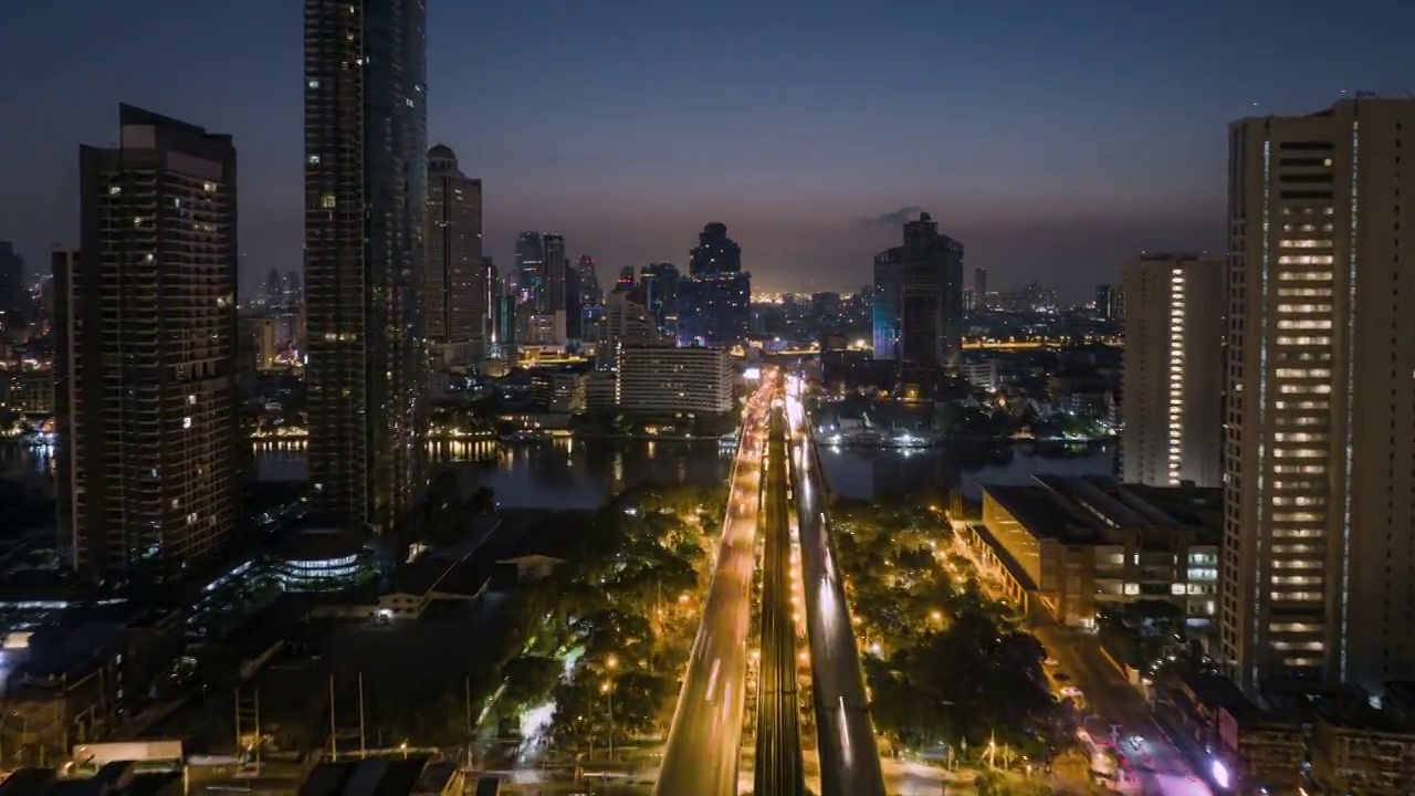 无人机超时间延时拍摄的日出场景，交通车灯在高速公路和地铁空中列车跨越湄南河在曼谷视频素材