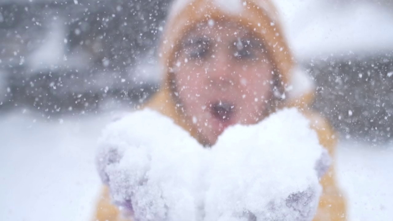 女孩从手中吹起雪花视频素材