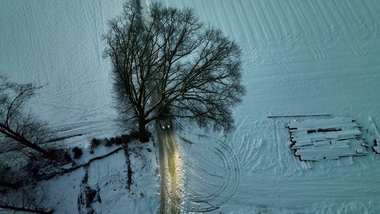 俯视图从无人机的越野车驾驶在冰雪道路探索当地的风景在冬季股票视频视频素材