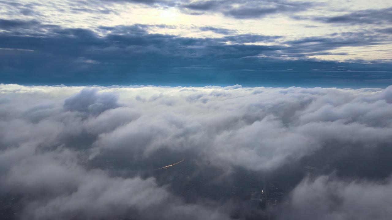 从高空俯瞰，在暴雨来临前，地面上覆盖着蓬松的雨云视频素材