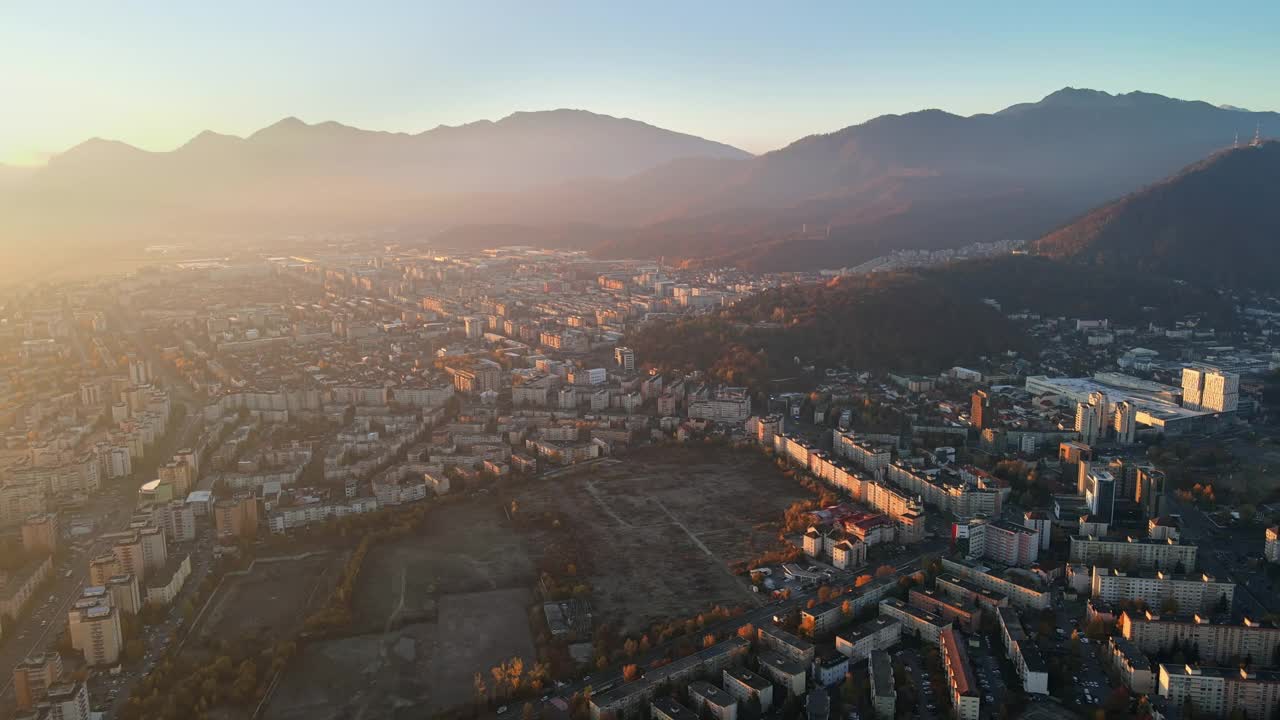 鸟瞰图，Brasov日出，罗马尼亚。道路上的汽车，住宅建筑，黄色的树木，喀尔巴阡山脉的背景。视频素材