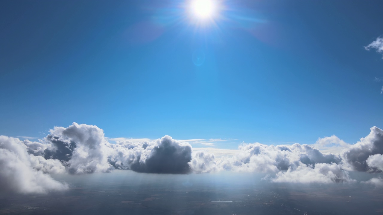 从飞机窗口高空俯瞰，在暴雨前形成的蓬松的积云覆盖着大地视频素材