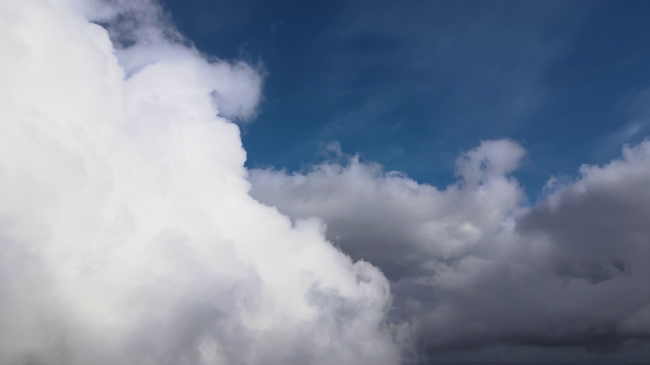 从飞机窗口高空俯瞰，在暴雨前形成的蓬松的积云覆盖着大地视频素材