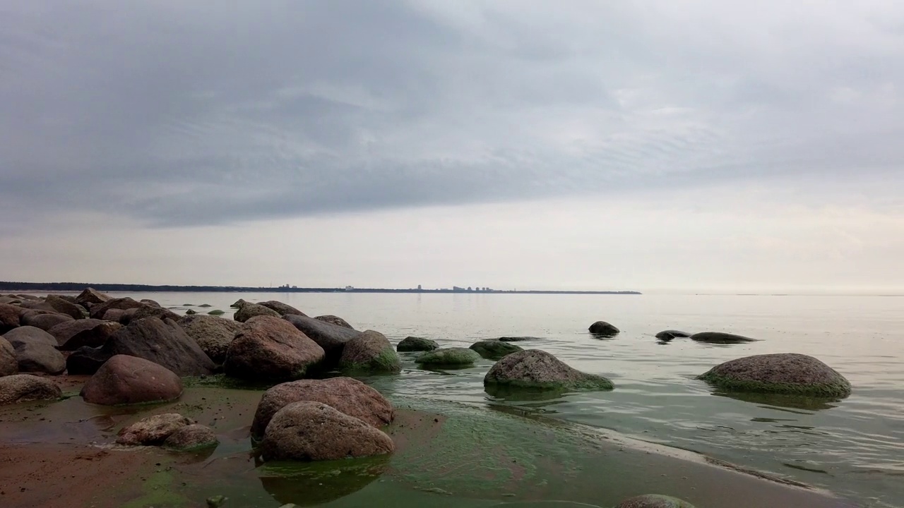 阴天的海景。视图从左向右移动。岸用石头视频素材