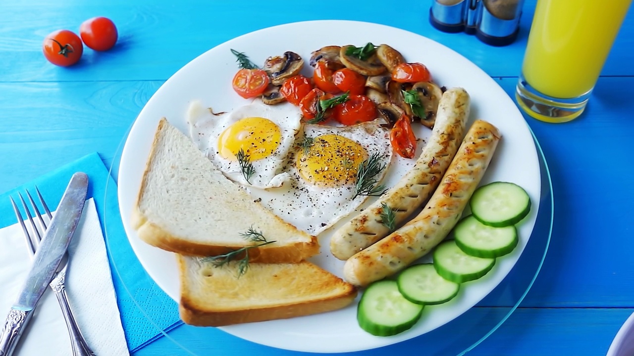 将香料洒在煎鸡蛋的蛋黄上，这是一张特写照片，在一个蓝色的早餐盘上。白色盘子上的早餐。4k慢动作视频。视频素材