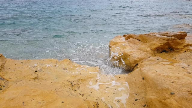 海浪拍打着黄色的石头视频素材