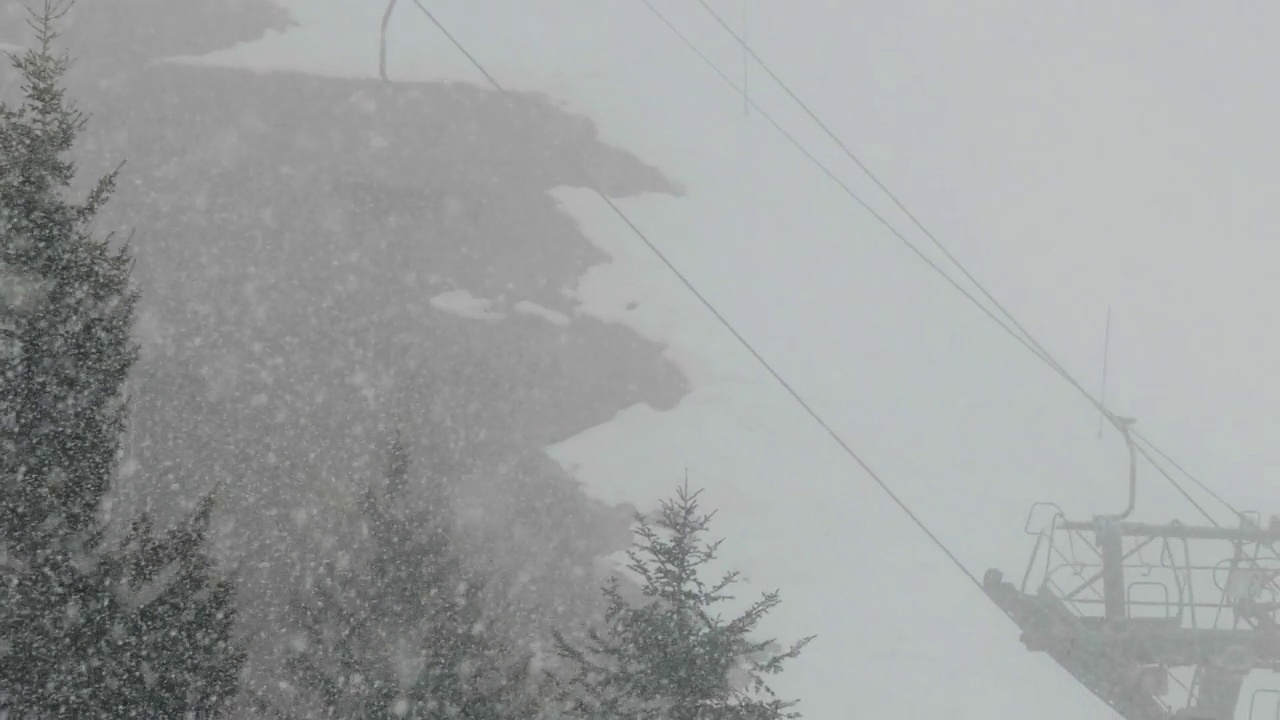 一些设施被大雪覆盖，缆车爬上陡峭的山坡，被山林覆盖视频素材