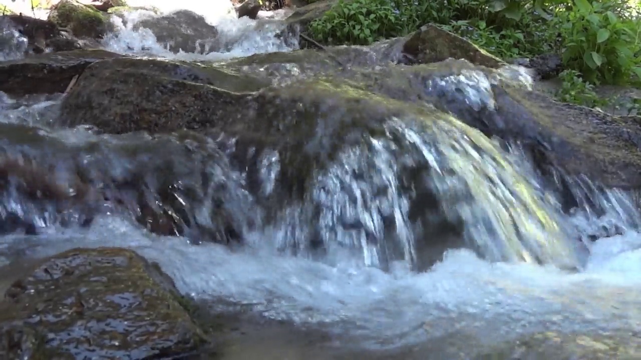 湍急的山河在流过巨石时形成瀑布视频素材