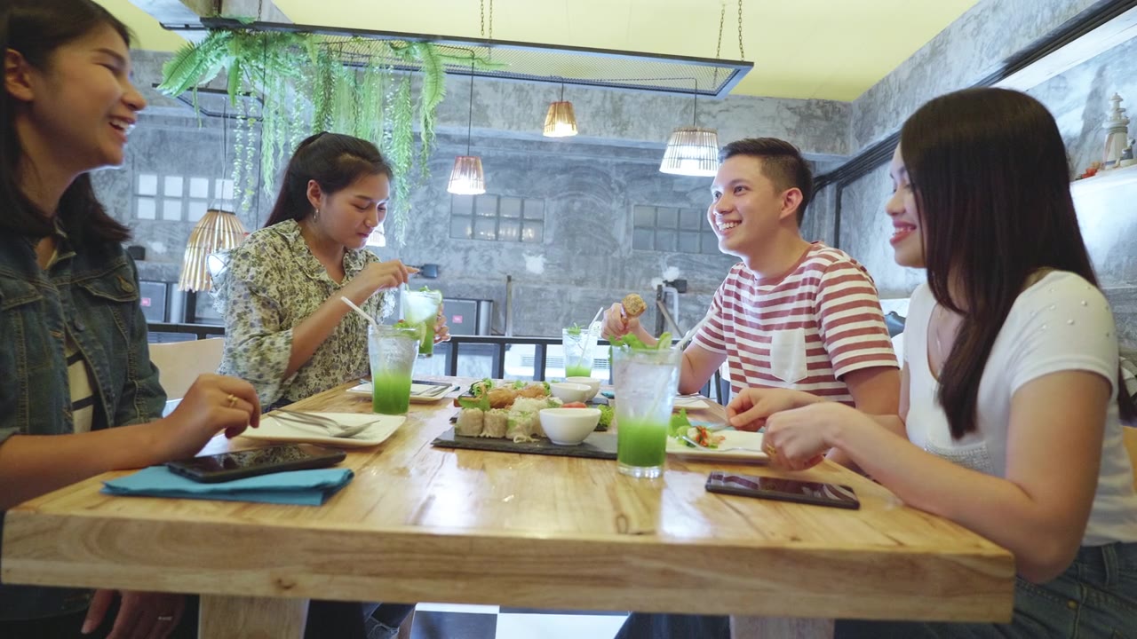 一群年轻的千禧一代喜欢在餐厅用餐视频素材画面2