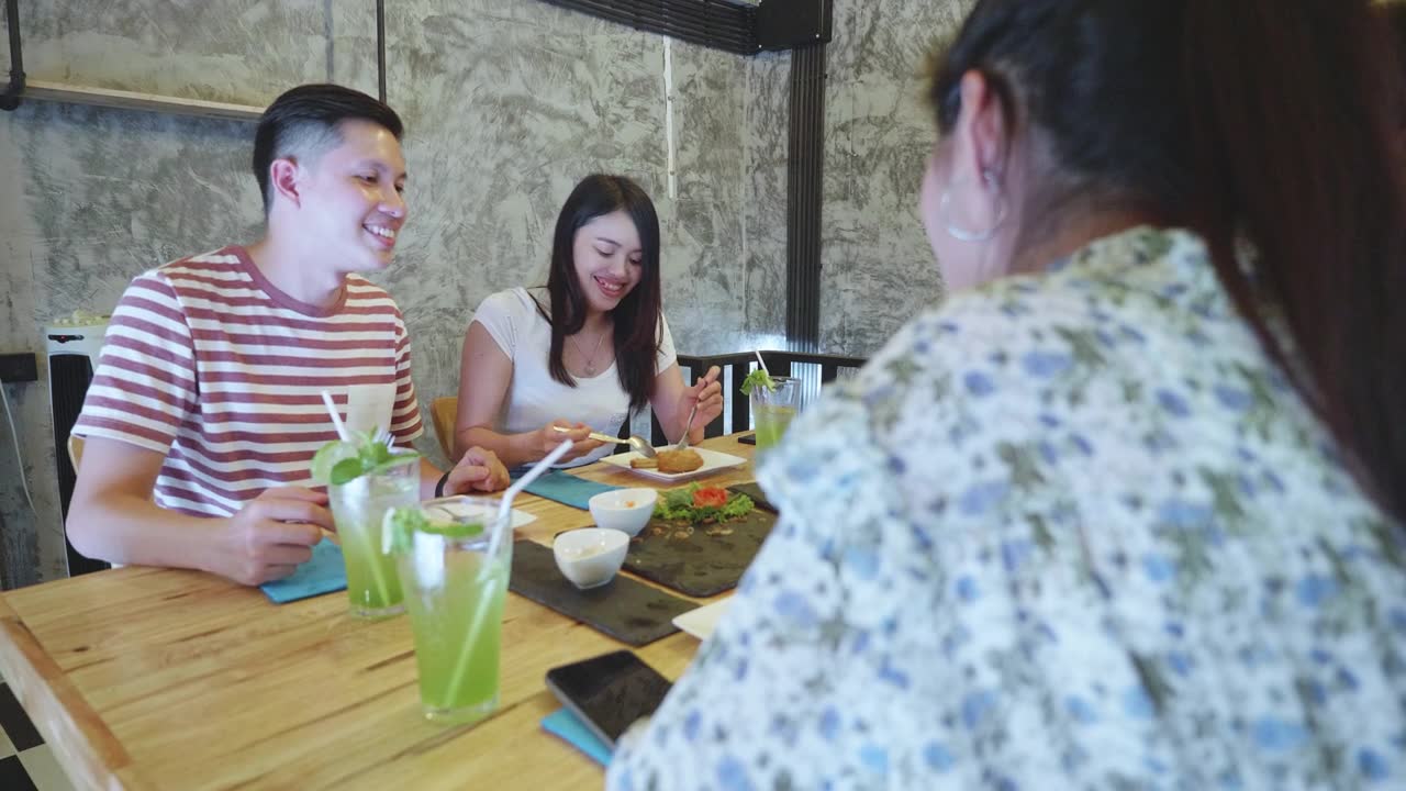 一群年轻的千禧一代喜欢在餐厅用餐视频素材画面1
