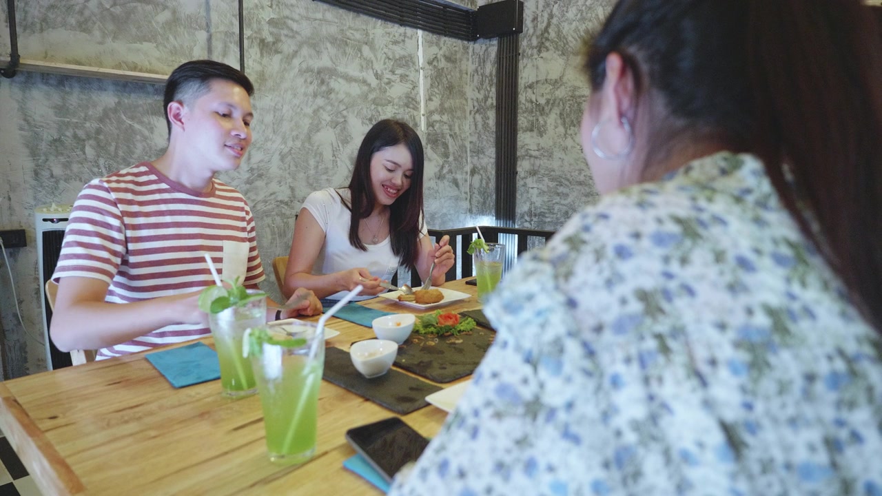 一群年轻的千禧一代喜欢在餐厅用餐视频素材画面2