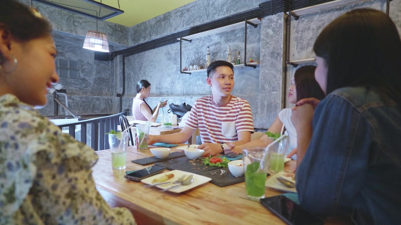 一群年轻的千禧一代喜欢在餐厅用餐视频素材画面2