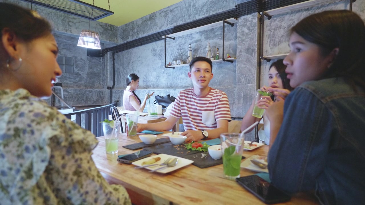 一群年轻的千禧一代喜欢在餐厅用餐视频素材画面3