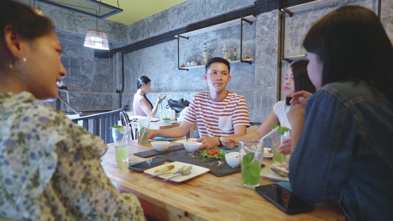 一群年轻的千禧一代喜欢在餐厅用餐视频素材画面4