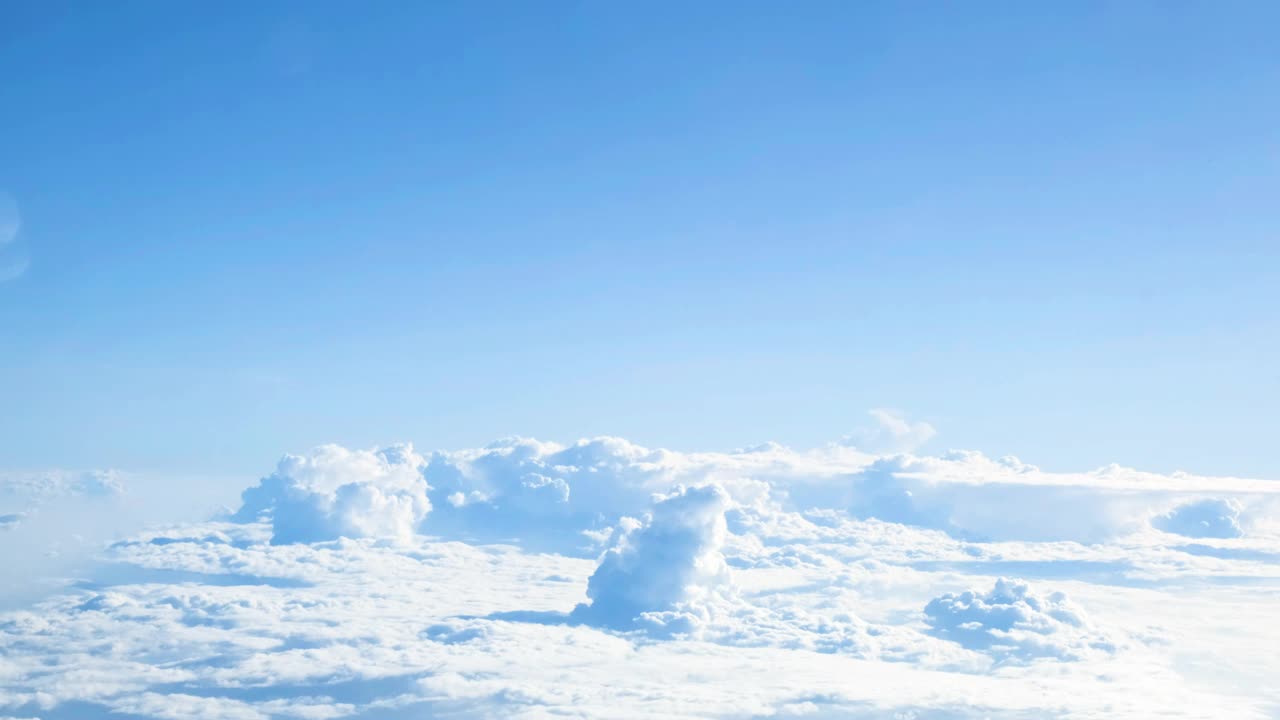 乘飞机旅行时，从窗口观看空中的天空和云景视频素材