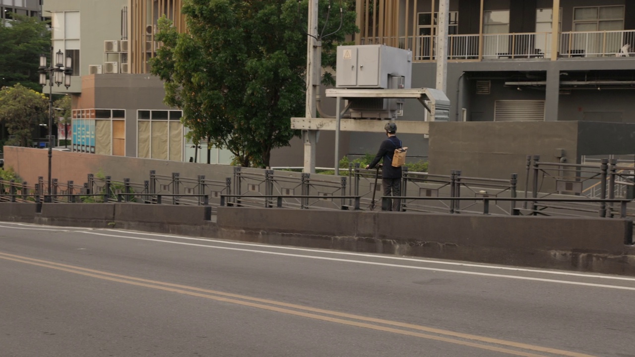 一个年轻人在自行车道上骑电动滑板车。城市生活。生态交通。都市男人骑电动滑板车。科技、环保的出行理念。视频素材