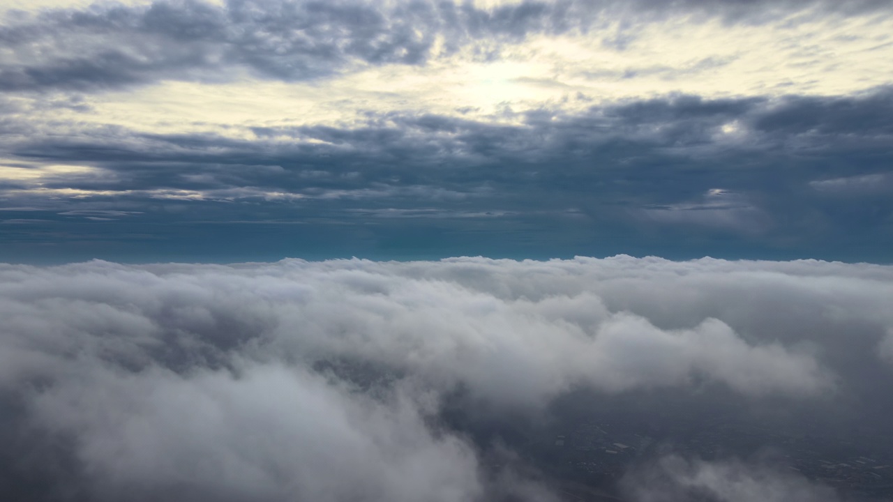 从高空俯瞰，在暴雨来临前，地面上覆盖着蓬松的雨云视频素材