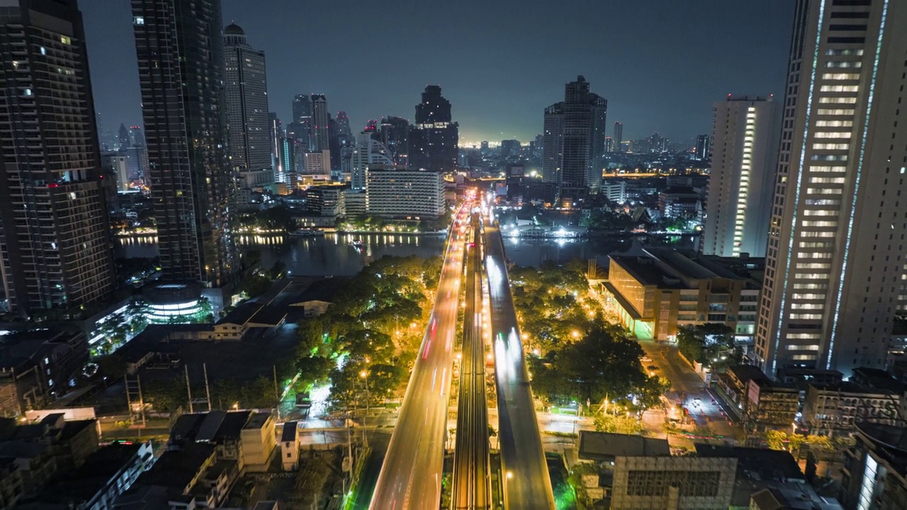 无人机超时间延时拍摄的日出场景，交通车灯在高速公路和地铁空中列车跨越湄南河在曼谷视频素材