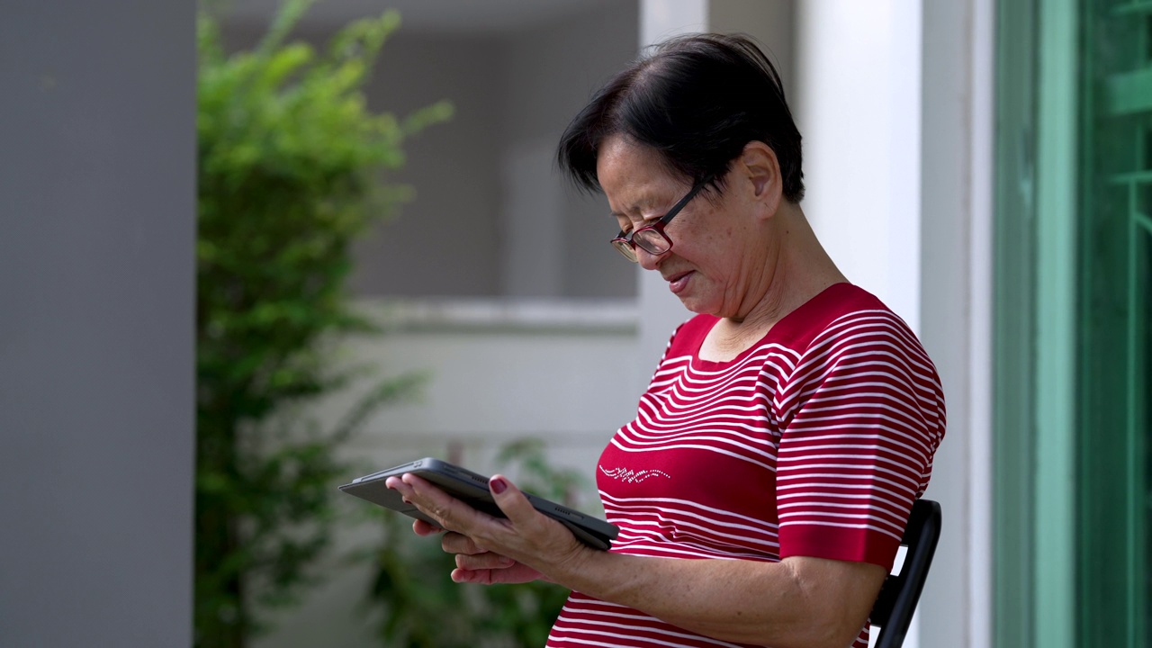 快乐退休女士，60岁，用触控板设备上网。视频素材