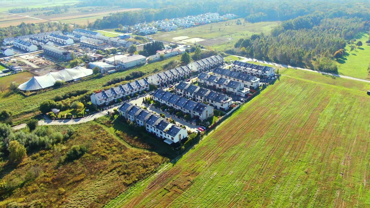 从空中俯瞰，五颜六色的秋天树木，住宅和庭院与排水池塘沿郊区街道视频素材