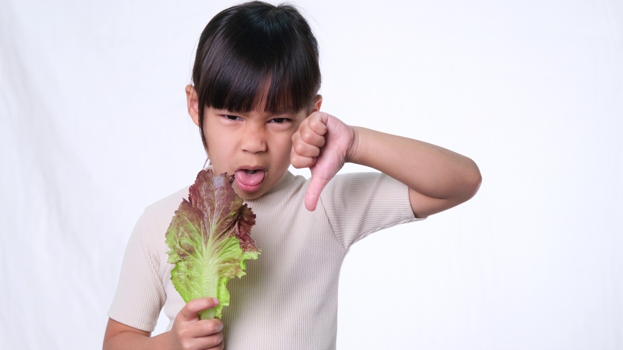 孩子们不喜欢吃蔬菜。讨厌吃蔬菜沙拉的小女孩。视频素材