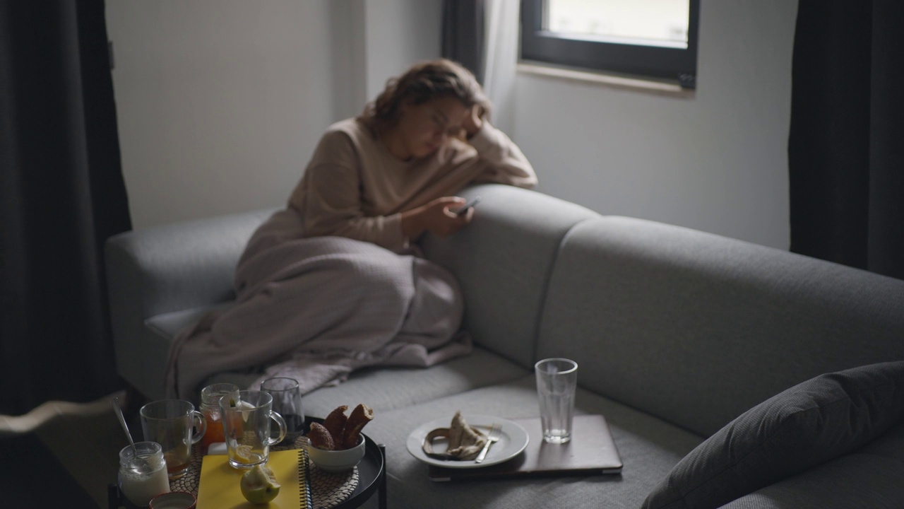 悲伤抑郁的女人在家里用智能手机视频素材