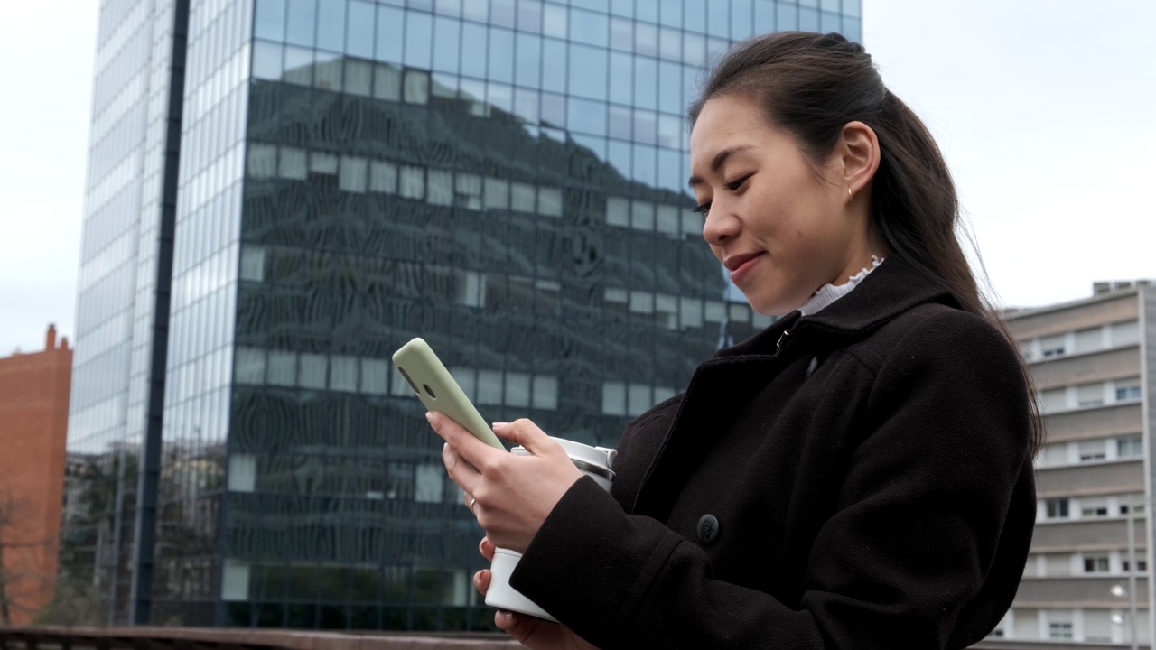 亚洲女商人在市中心用智能手机视频素材