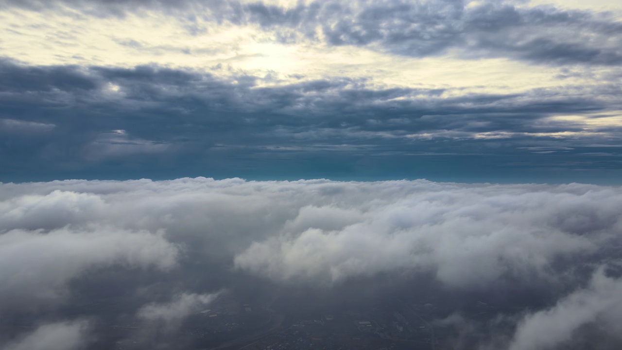 从高空俯瞰，在暴雨来临前，地面上覆盖着蓬松的雨云视频素材