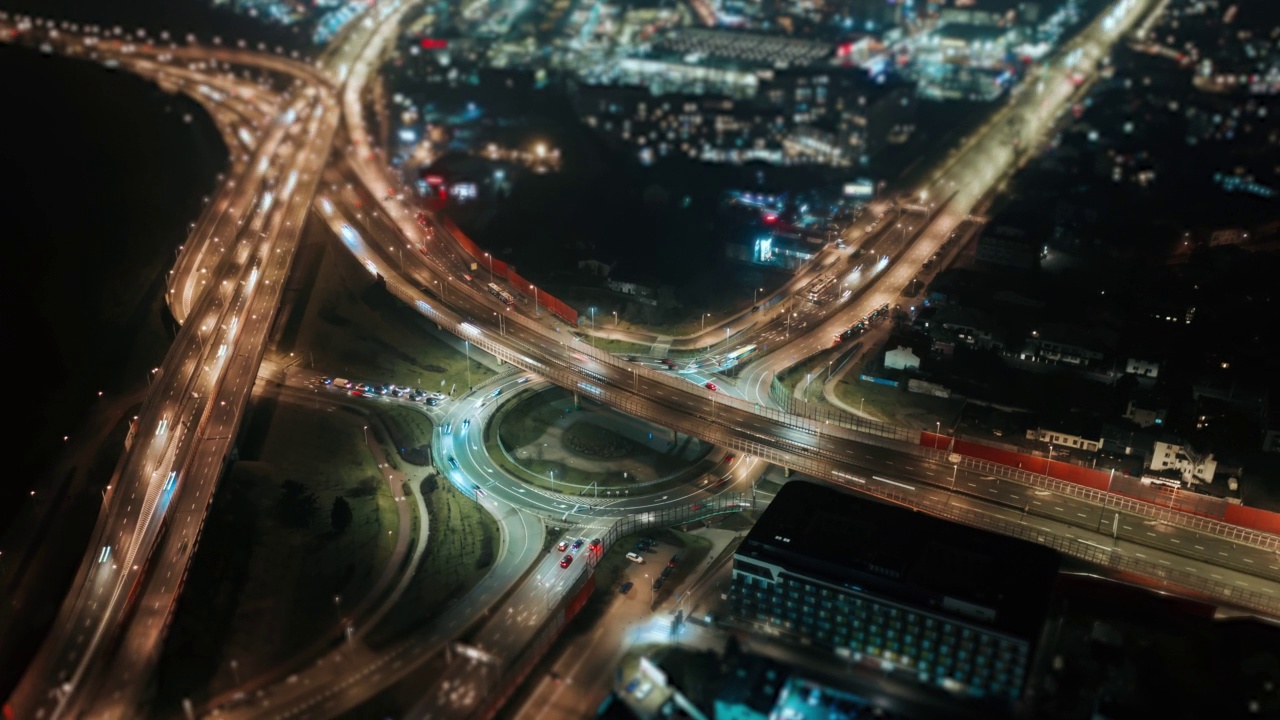 夜间无人机延时超高速汽车交通环行立交道路，夜间俯视图交叉路口高速公路交叉口。立交桥城市风光驾驶繁忙十字路口，倾斜移位模糊效果视频素材