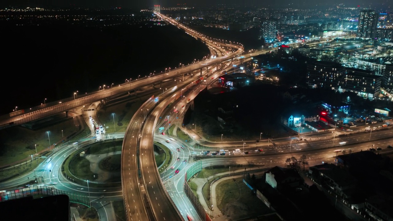 在现代大城市中，无人机延时超高速汽车交通夜间环行立交道路、俯视图交叉路口夜间高速公路交叉口。立交桥城市风光驾驶繁忙的十字路口视频素材