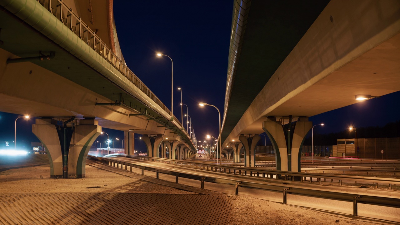 夜晚大城市的汽车交通、道路交叉口、高速公路延时。广角时间间隔汽车行驶在繁忙的立交十字路口快速运动。光线轨迹。交通基础设施发展视频素材