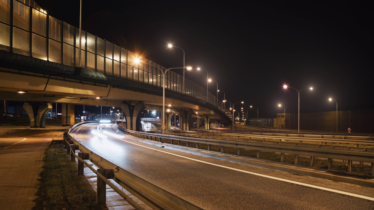 夜晚大城市的汽车交通、道路交叉口、高速公路延时。广角时间间隔汽车行驶在繁忙的立交十字路口快速运动。光线轨迹。交通基础设施发展视频素材