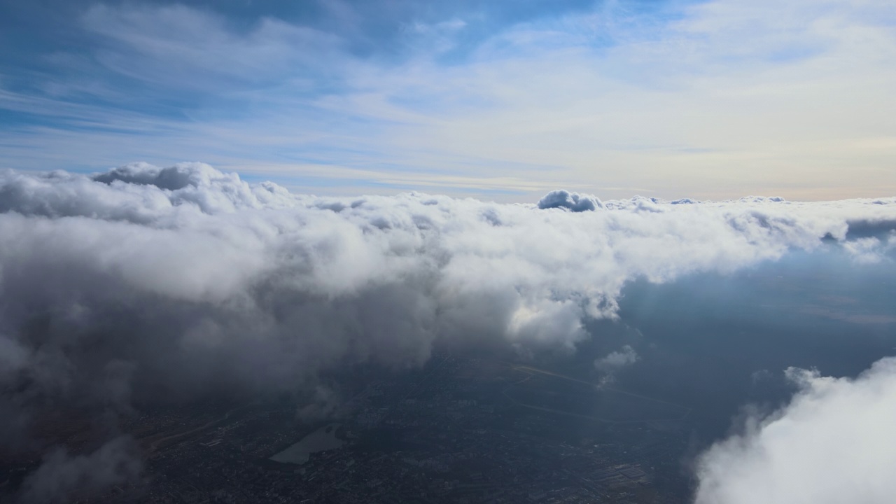 从飞机窗口高空俯瞰，在暴雨前形成的蓬松的积云覆盖着大地视频素材