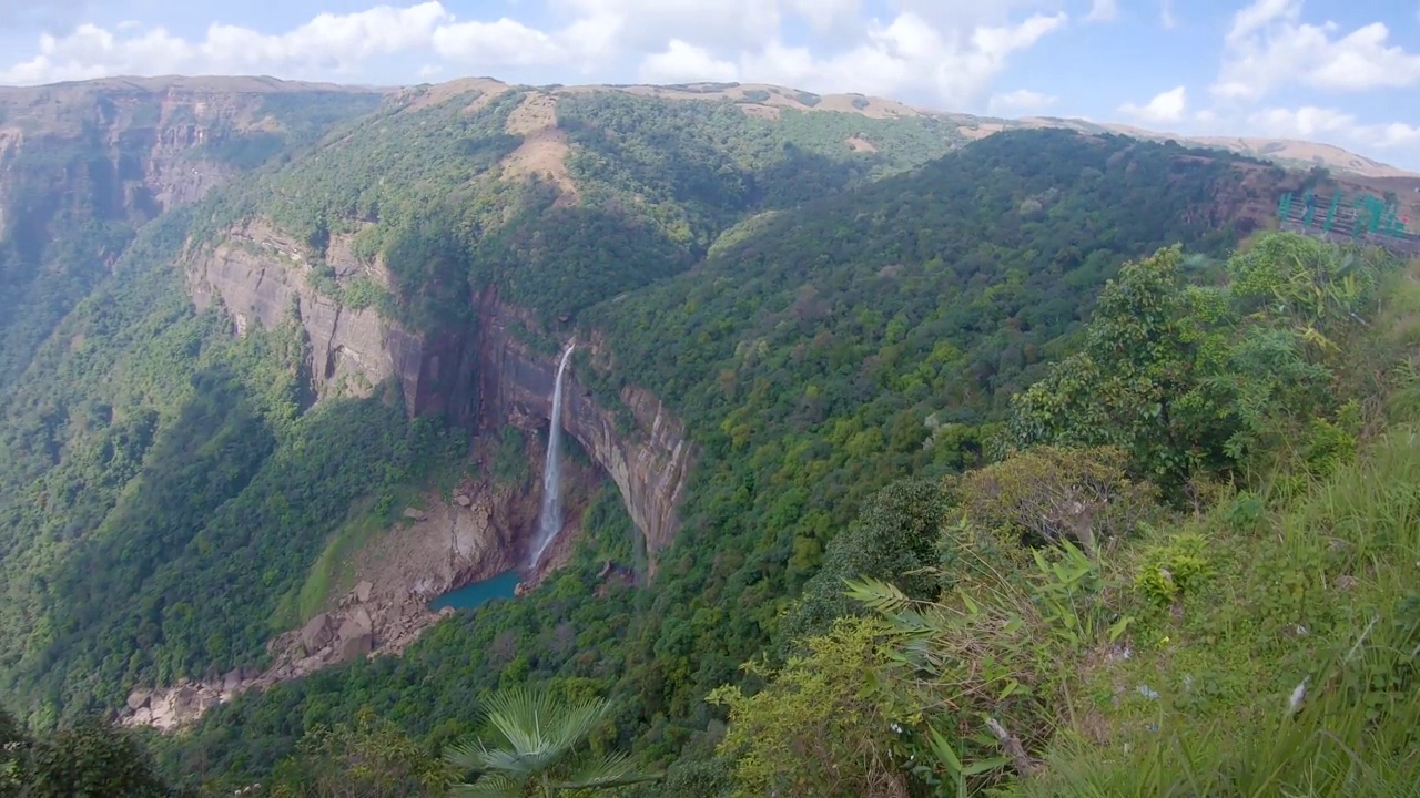 孤零零的瀑布从山顶坠落，从山顶角度依偎在绿色的森林中视频素材