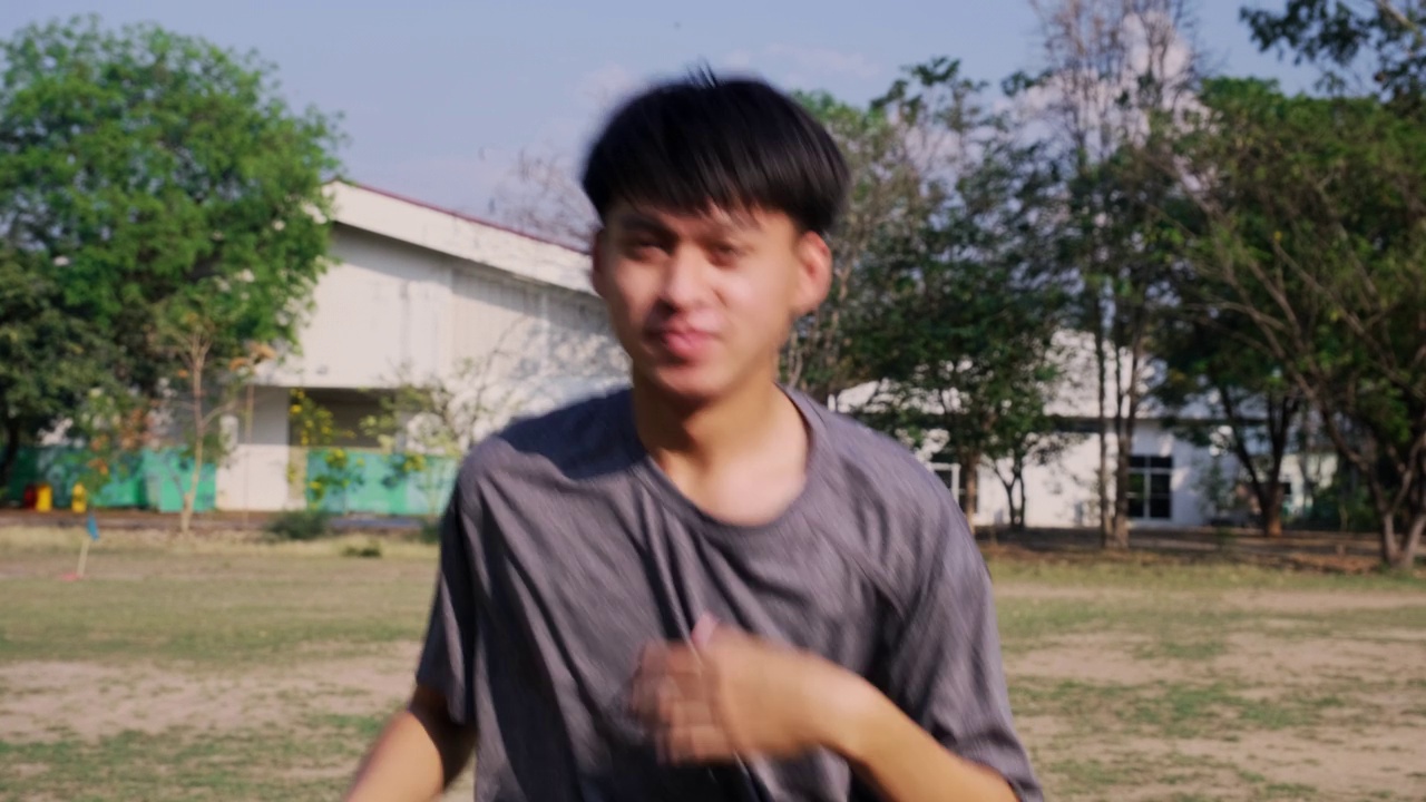 健康的年轻人在公园跑步前伸展身体热身。运动中动态运动和有氧训练的概念。视频素材画面2