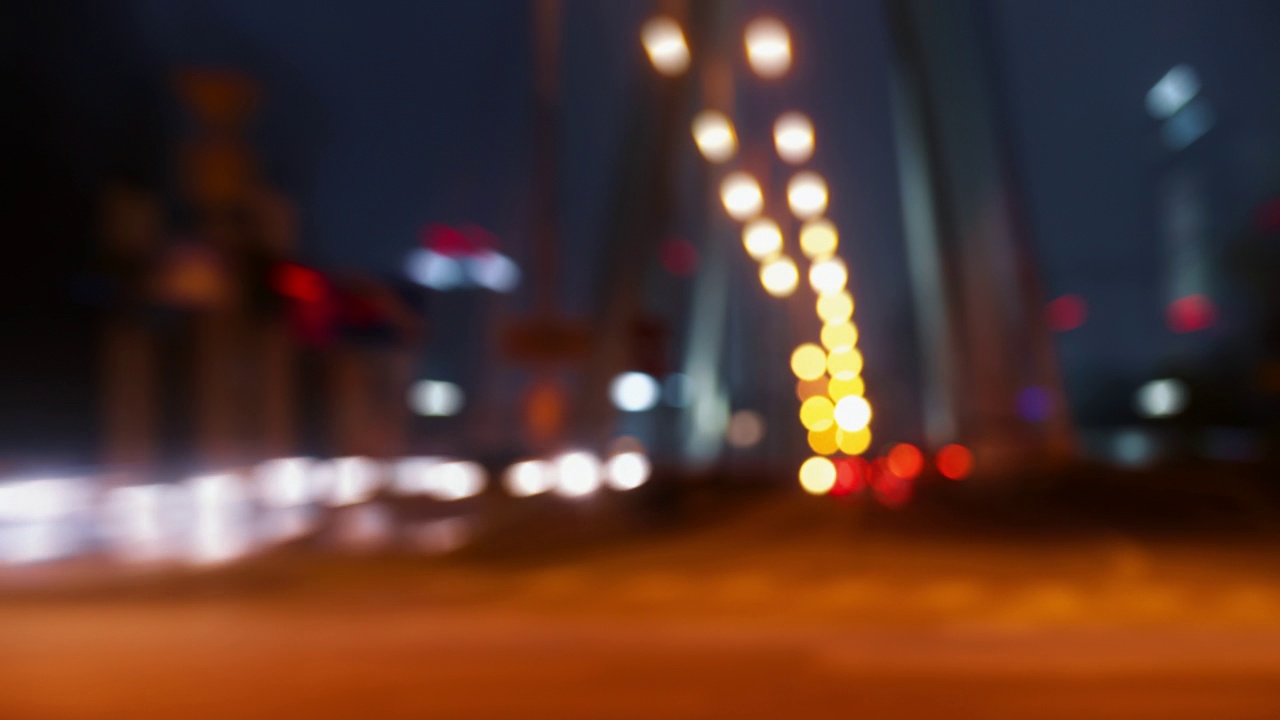 散景模糊了夜晚城市道路上的交通堵塞。时间推移，繁忙的交通高峰期，十字路口的桥面巷道。夜晚的汽车，快速移动的灯光。灯光尾随运动抽象背景视频素材