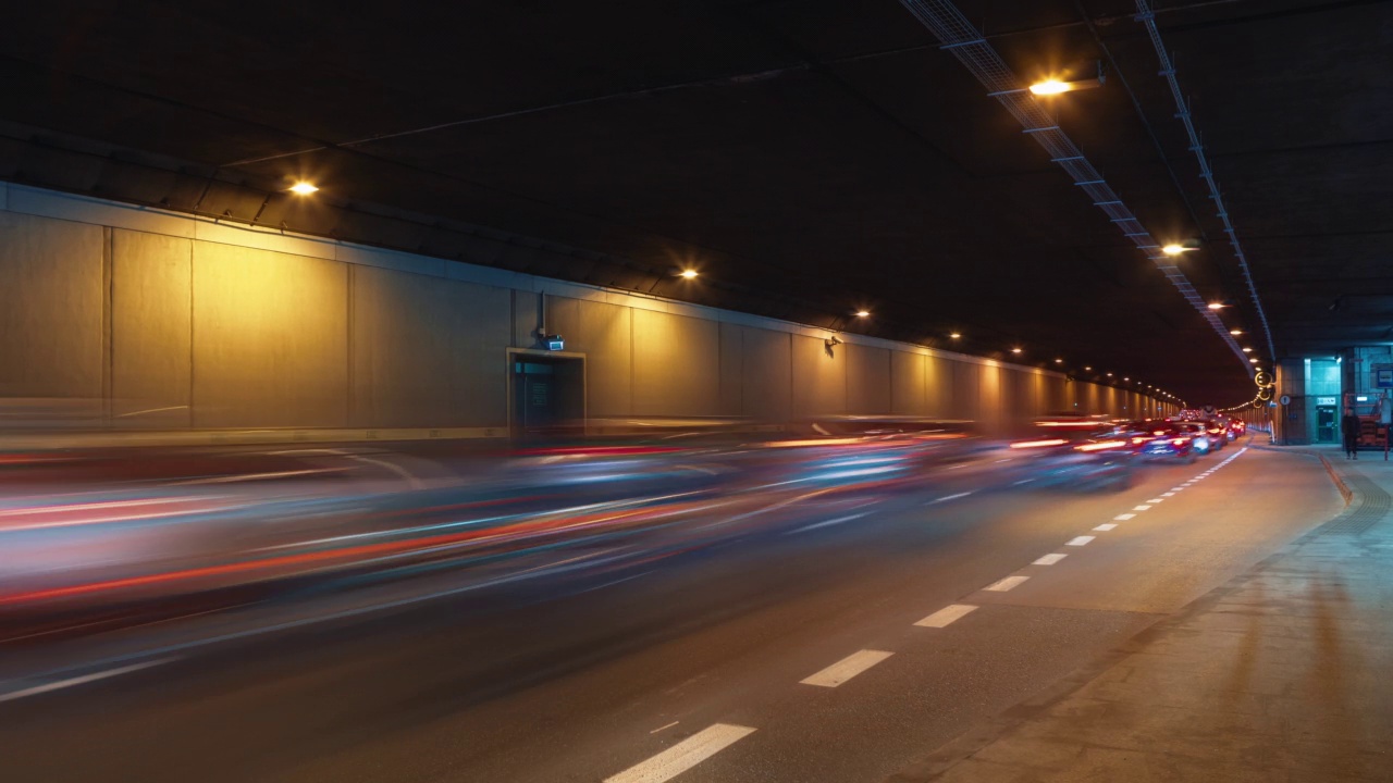 现代大城市夜间广角延时交通堵塞地下通道道路、隧道地下通道道路。繁忙公路的时间间隔。车流高峰时行驶，车灯紧跟着快速移动视频素材