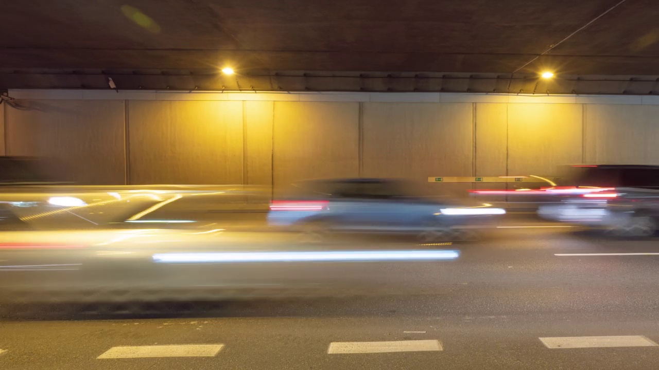 现代大城市夜晚延时交通堵塞的地下通道、隧道地下通道。夜间繁忙公路的时间间隔。车流高峰时行驶，车灯紧跟着快速移动视频素材