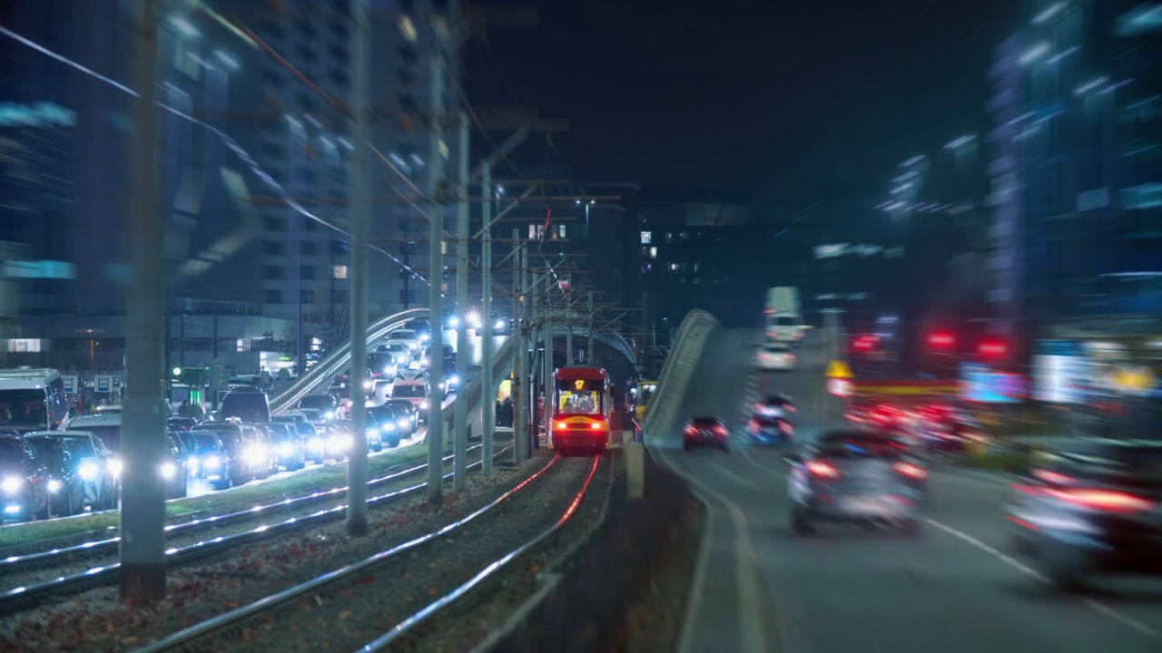 夜晚立交桥交通堵塞，黄色有轨电车在大城市夜晚快速行驶。时光流逝，繁忙的市区高速公路。车流高峰时行车，车灯尾随运动。城市生活、交通运输视频素材