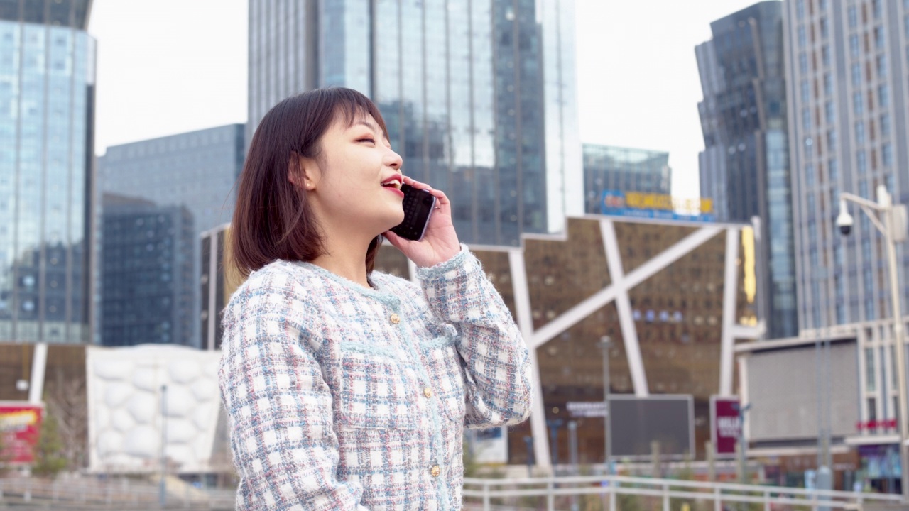 亚洲年轻女子在城市街道上使用智能手机视频素材